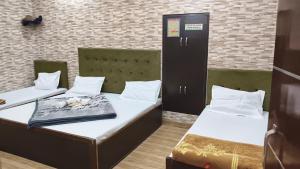 two beds in a dorm room with at Qasmi Hotel in Jammu