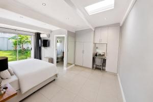 a white bedroom with a bed and a desk at Pet-Friendly, 3-Bed, 2-Bath in Knysna Central in Knysna