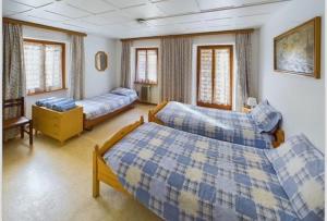 a bedroom with two beds in a room with windows at pensione VAIS in Piotta