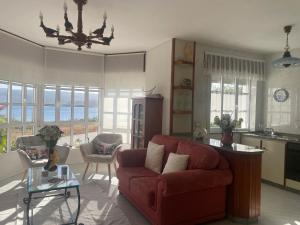 a living room with a red couch and a kitchen at Comfortable house with sea view in Viveiro, 200 m² in Viveiro +12 photos