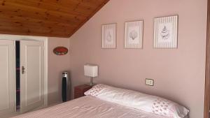 a bedroom with a bed and four pictures on the wall at Comfortable house with sea view in Viveiro, 200 m² in Viveiro