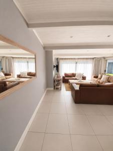 a large living room with couches and a mirror at Pet-Friendly, 3-Bed, 2-Bath in Knysna Central in Knysna
