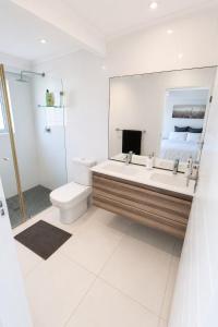 a bathroom with a sink and a toilet and a mirror at Pet-Friendly, 3-Bed, 2-Bath in Knysna Central in Knysna +40 photos