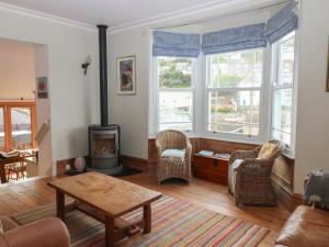 a living room with a fireplace and a table and chairs at Kipper Lodge in Dartmouth