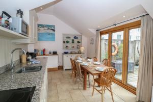 a kitchen with a wooden table and chairs and a dining room at Kipper Lodge in Dartmouth