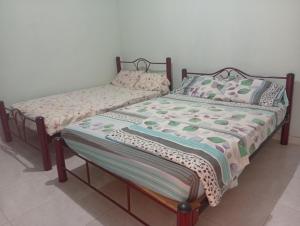 two beds sitting next to each other in a room at Casa Hotel el Sueño in Villavieja