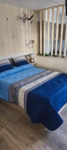 a bed with a blue comforter in a bedroom at O casal in Cambados