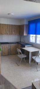 a kitchen with a table and two chairs in it at O casal in Cambados