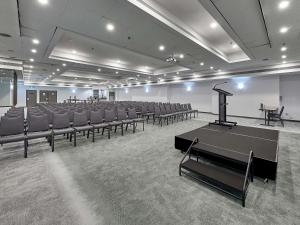 a large room with chairs and a stage in it at ibis Perth in Perth