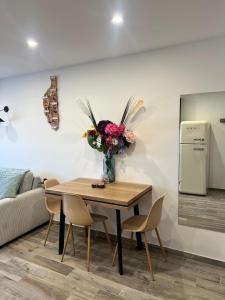 a dining room with a table with a vase of flowers at Charmant studio île & cap in Bastia