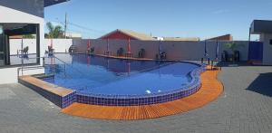a large swimming pool with blue water in a building at Pousada Rancho do Sossego in Céu Azul