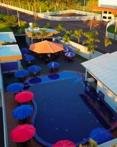 an overhead view of a pool with umbrellas and tables at Pousada Rancho do Sossego in Céu Azul