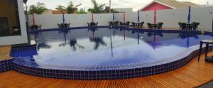 a large swimming pool with black chairs around it at Pousada Rancho do Sossego in Céu Azul