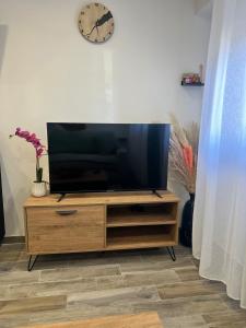 a flat screen tv sitting on top of a wooden entertainment center at Charmant studio île & cap in Bastia