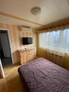 a bedroom with a bed and a flat screen tv at Mugavustega avar perekorter 3toaline in Võru