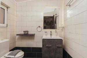 a bathroom with a toilet and a sink and a mirror at Level 3 Sea View Studio in Planos +17 photos