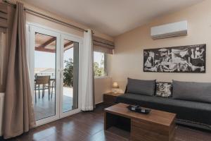 a living room with a couch and a table at Level 3 Sea View Studio in Planos