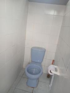 a bathroom with a blue toilet and a roll of toilet paper at Casa Hotel el Sueño in Villavieja