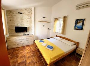 a bedroom with a large bed and a television at Apartments Maris in Petrovac na Moru