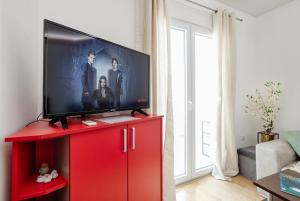 a flat screen tv on a red cabinet in a living room at Apartman Stella Đenovići in Đenovići