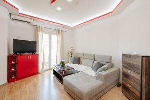 a living room with a couch and a flat screen tv at Apartman Stella Đenovići in Đenovići