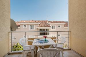 a balcony with a table and chairs and a building at Apartman Stella Đenovići in Đenovići +12 photos