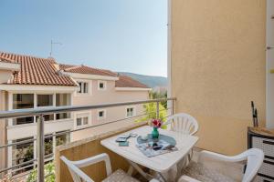 a balcony with a table and chairs on a balcony at Apartman Stella Đenovići in Đenovići