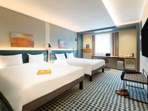 ein Hotelzimmer mit zwei Betten und einem Schreibtisch in der Unterkunft Novotel Luxembourg Kirchberg in Luxemburg (Stadt) + 251 Fotos