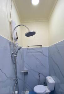 a bathroom with a shower with a toilet and a shower head at EcoWave Retreat- Muli in Muli