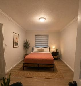 a bedroom with a bed with a orange blanket at Santorini Shores in Biscayne Park