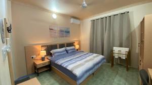 a bedroom with a bed and a night stand with two lamps at EcoWave Retreat- Muli in Muli