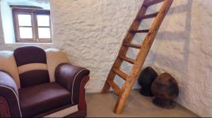 a stairway with a chair and a wooden ladder at Lodge La Ilusión in Ibarra