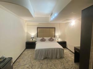 a hotel room with a bed and two lamps at فندق قصر السدير in Baghdād