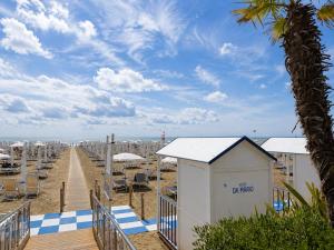 a view of a beach with chairs and a building at Hotel Da Mario in Caorle