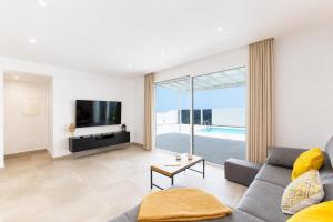 a living room with a couch and a tv at Villa Maria 7 in Puerto Calero