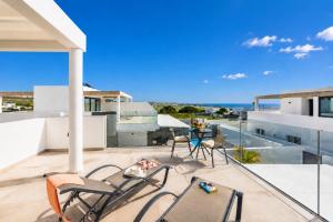 a balcony with chairs and a table on a building at Villa Maria 7 in Puerto Calero