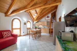 a kitchen and living room with a red couch at Casa Bamby in Cogolo