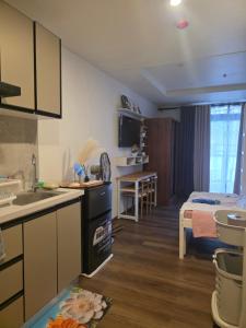 a kitchen and living room with a bed in the background at Megarich Studio in Megatower VII in Baguio