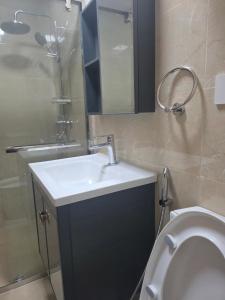 a bathroom with a sink and a shower and a toilet at Megarich Studio in Megatower VII in Baguio