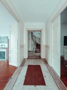 an empty living room with a stairway with a red rug at La Canopée in Verdun-sur-Meuse
