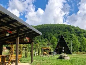 a black triangular building in a field with a playground at Escape Remeti - Aframe by the River in Remeţi