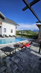 a couple of people laying on lounge chairs next to a swimming pool at CASA VIKI in Bănicel