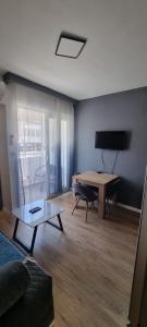 a living room with a table and a couch at Tri Kule Apartman in Bar