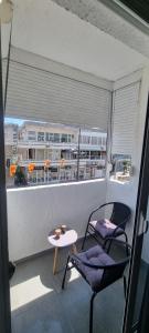 a balcony with two chairs and a table and a window at Tri Kule Apartman in Bar