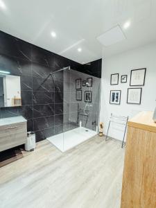 a bathroom with a shower and a bath tub at La Canopée in Verdun-sur-Meuse +18 photos