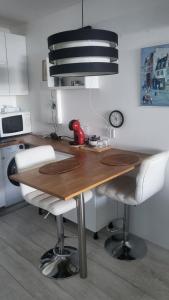 a kitchen with a wooden table and white chairs at Costa Plana apartment with terrace and sea view in Cap d'Ail +11 photos