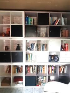 a white book shelf filled with books at Charming Villa close to the sea in Errindlev