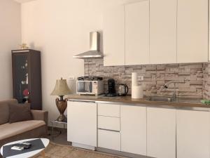 a kitchen with white cabinets and a microwave at Cozy spacious apartment in Peje