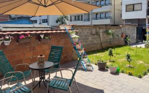 a patio with a table and an umbrella and a ladder at Cozy spacious apartment in Peje