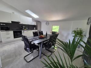 a kitchen with a table and chairs in a room at Apartmaji I&E in Sežana